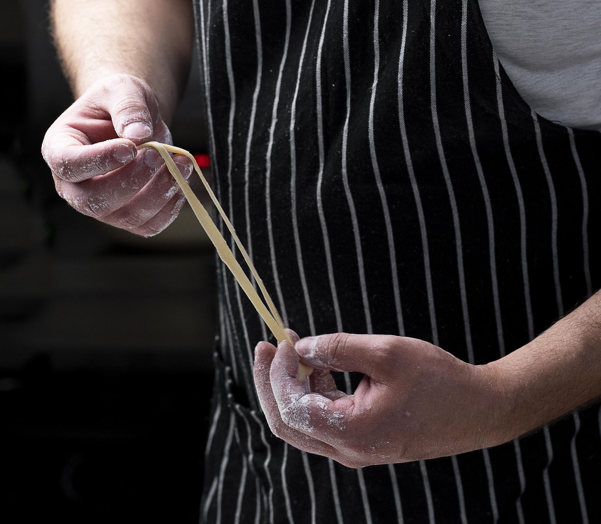 Chef plating a composed dish with tweezers